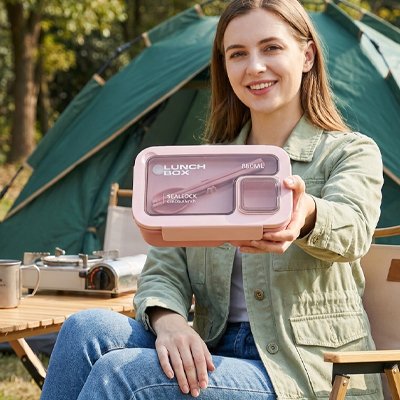 Lunch box femme tiens dans sa main une boite rose