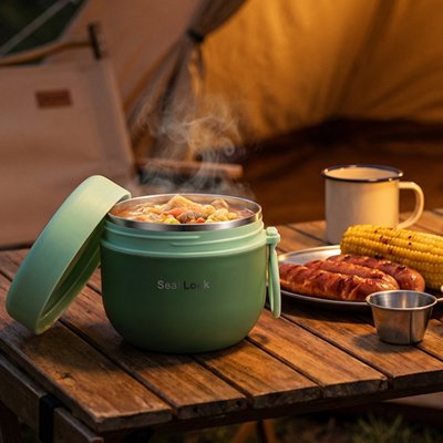 Lunch box sur une table avec soupe fumante